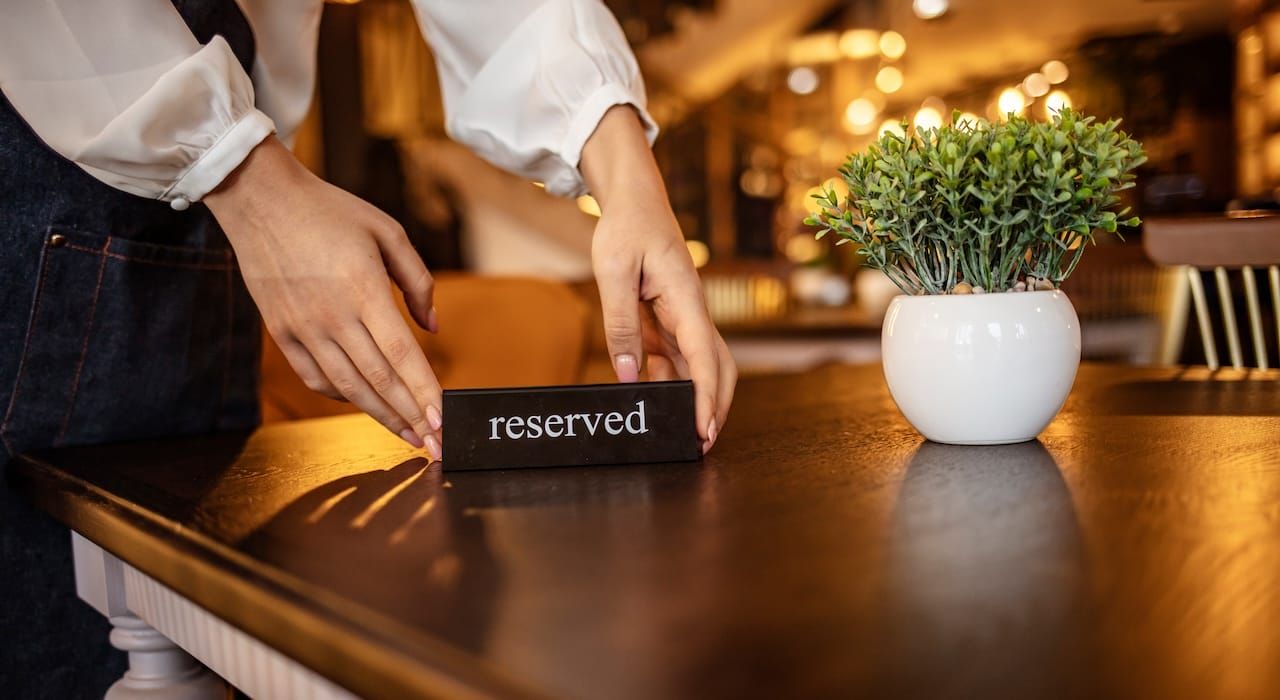 staff placing a 'reserved' sign on the restaurant table