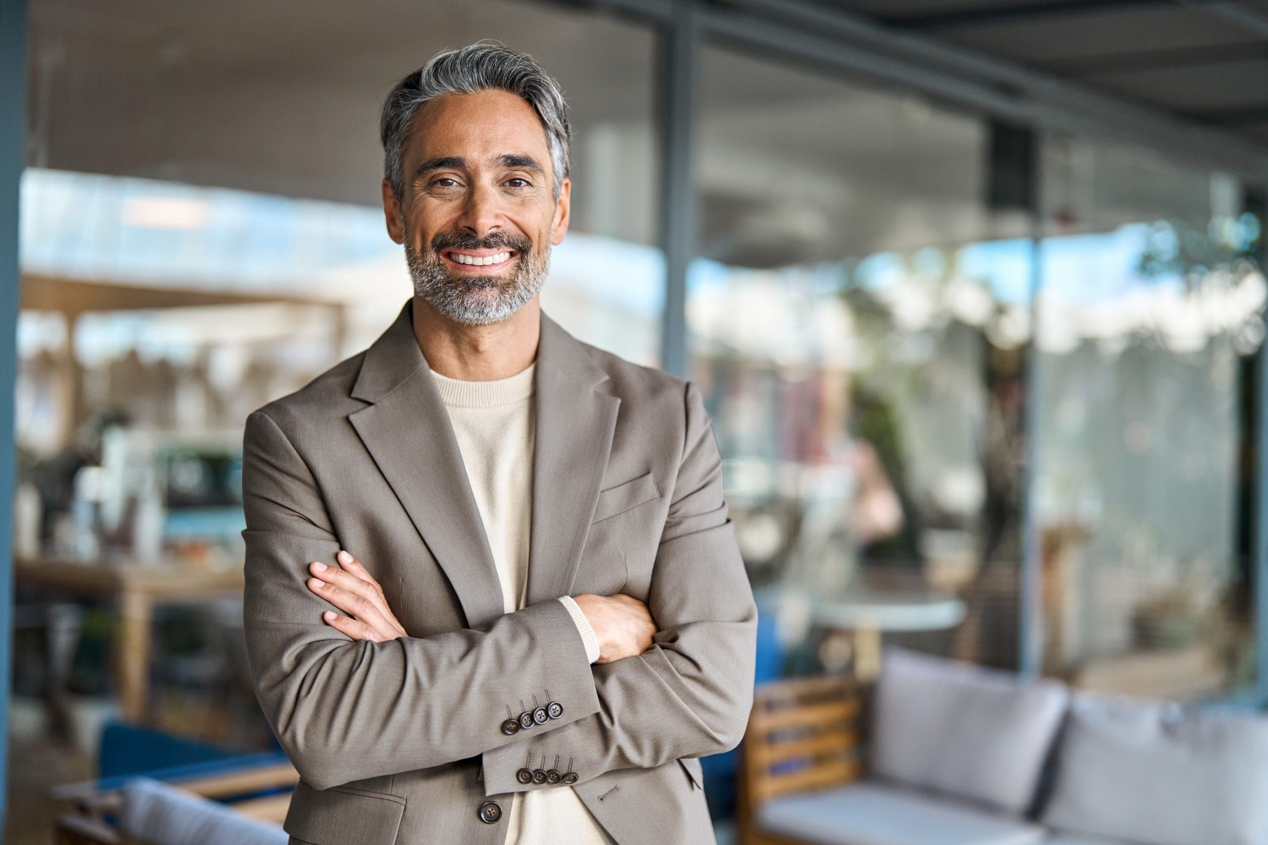 A male Director of Restaurant Operations smiling with his arms crossed