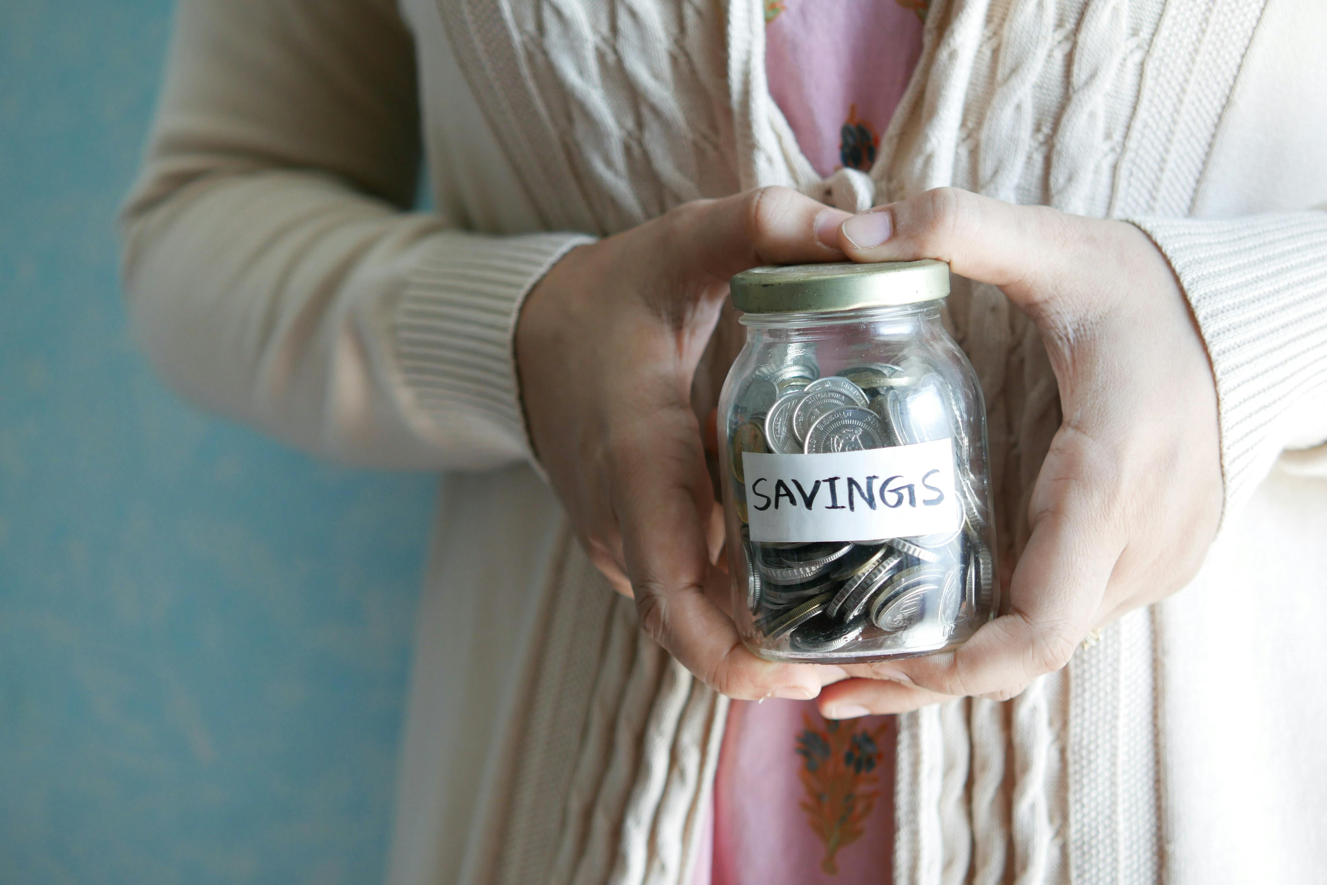 lady holding jar full of coins
