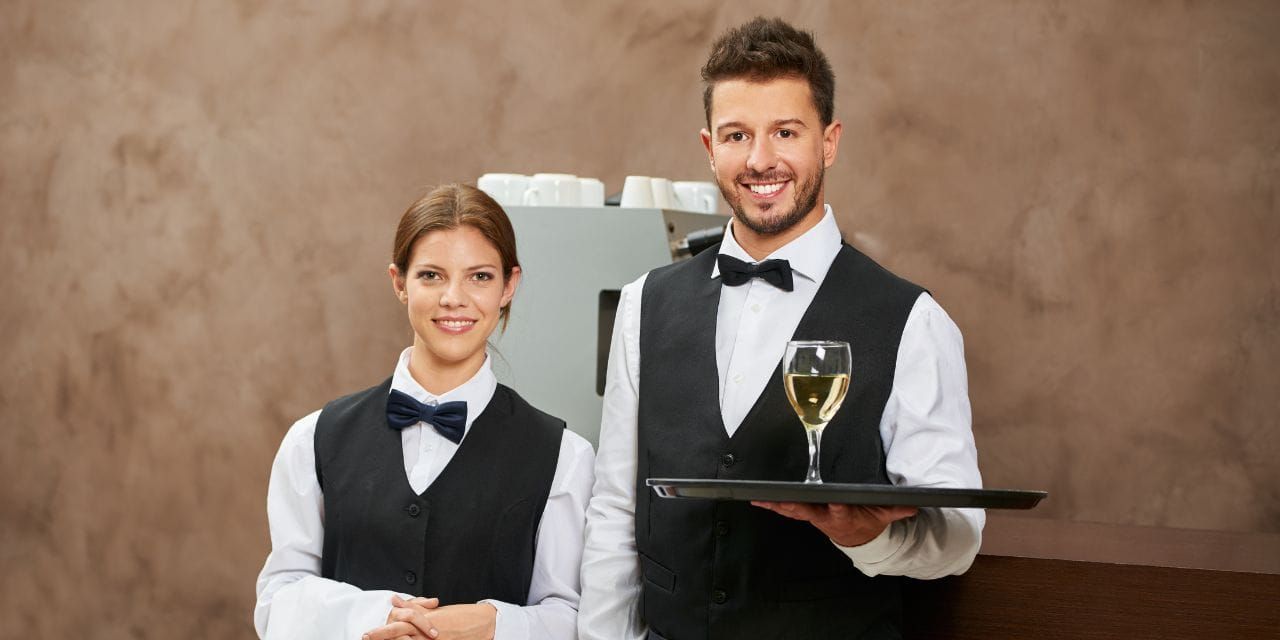 two fine dining servers smiling for the camera