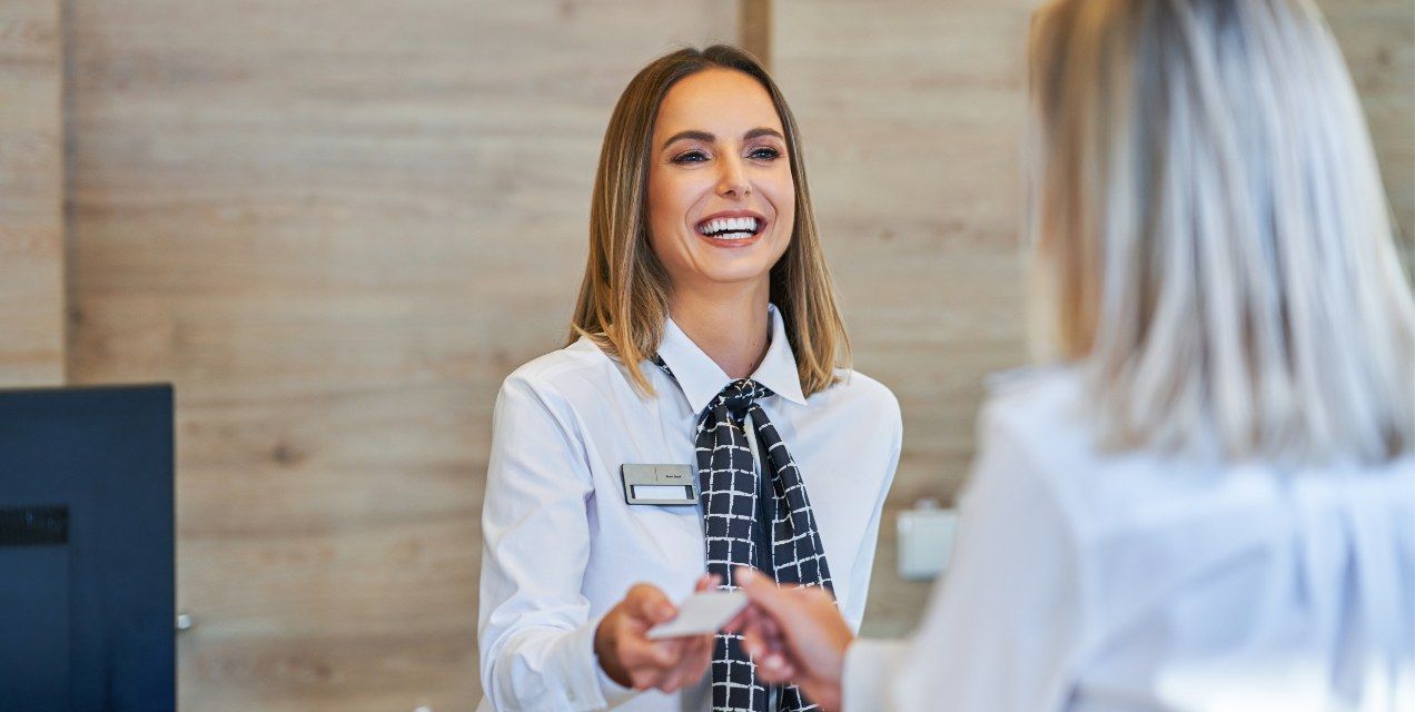 A female Hotel Front Desk Agent talking to a female guest